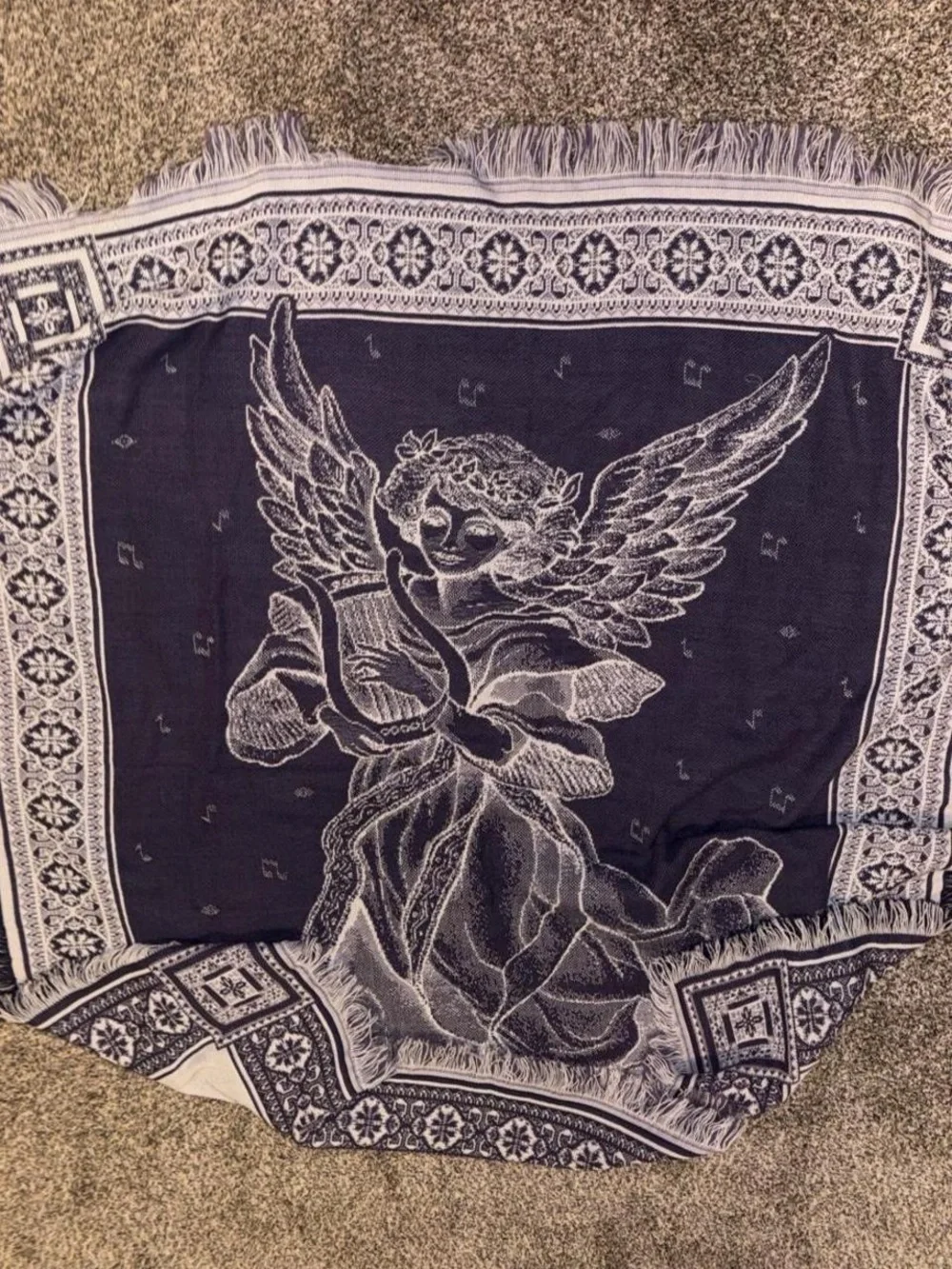 Purple and white tapestry blanket with music notes and angel playing harp